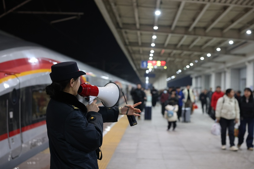 李婉蓉在站台上引導換乘旅客進入候車室。吳楚月攝