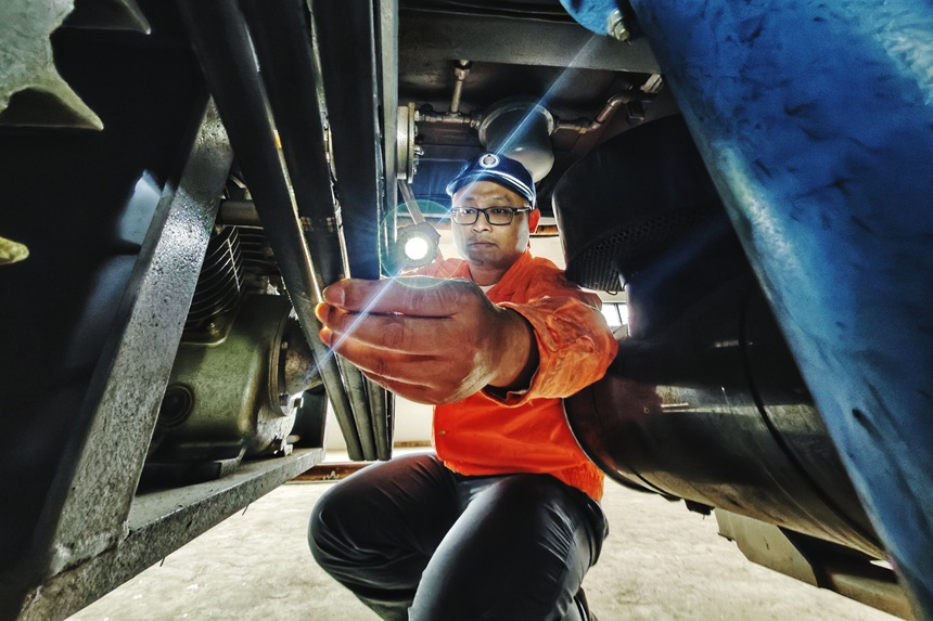 龔雄正在檢查空壓機。代槐孚攝