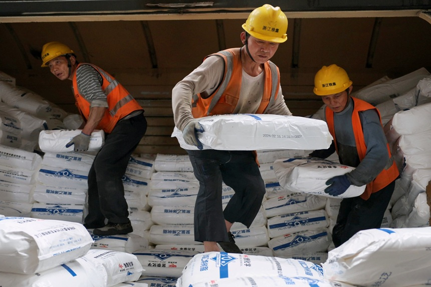 工人正在卸車搬運貨物。蔣楓攝