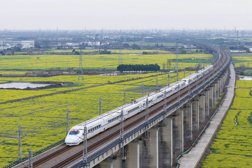 高鐵列車從油菜花田邊駛過。王志鑫攝