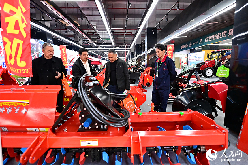 農機市場內，農戶們在咨詢選購農機設備。人民網記者 朱海鵬攝
