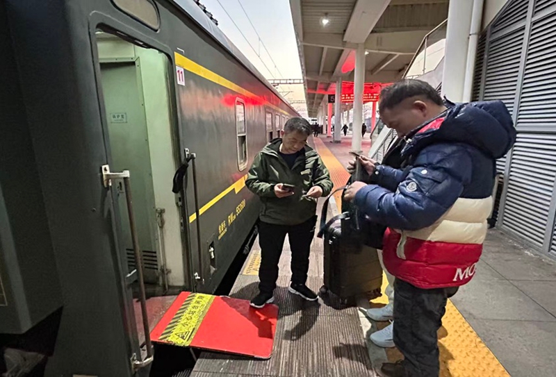 临客乘务员用手持终端机核对旅客乘车信息。吕轩摄