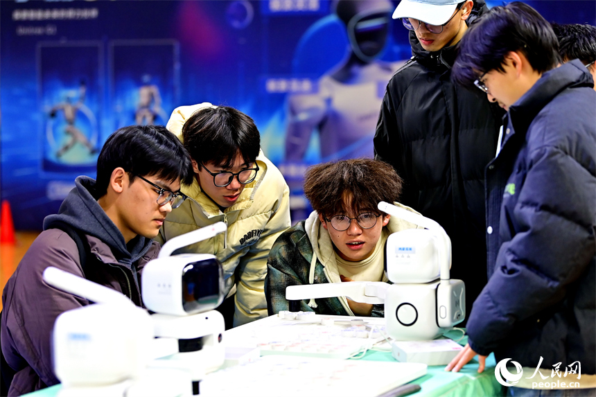 青少年学生和市民在机器人科普展现场体验机器狗、群舞机器人、下棋机器人。人民网记者 朱海鹏摄
