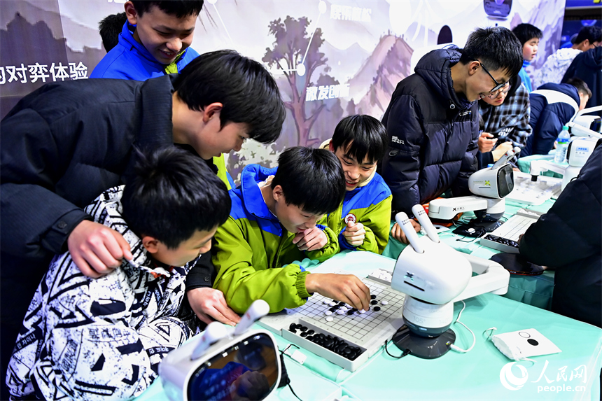 青少年学生和市民在机器人科普展现场体验机器狗、群舞机器人、下棋机器人。人民网记者 朱海鹏摄