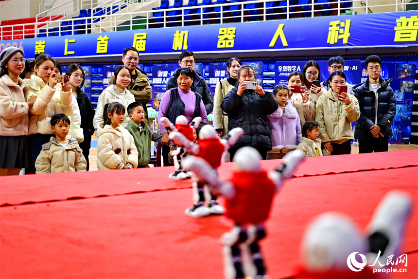 青少年学生和市民在机器人科普展现场体验机器狗、群舞机器人、下棋机器人。人民网记者 朱海鹏摄
