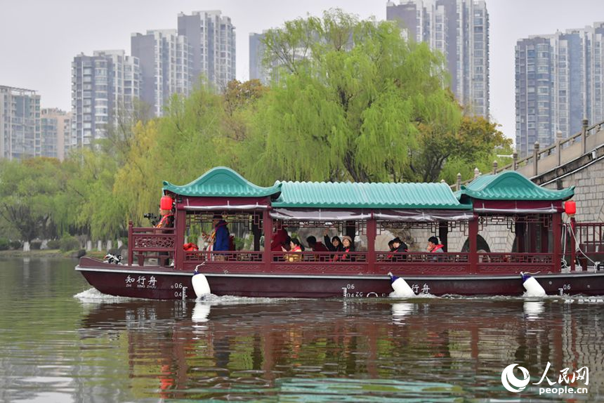 游船在象湖水面游弋，游客观赏两岸春光。人民网记者 时雨摄