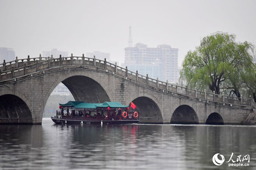 游船在象湖水面游弋，游客观赏两岸春光。人民网记者 时雨摄