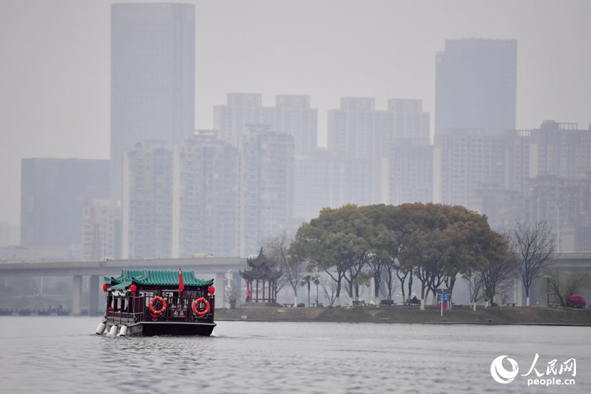 游船在象湖水面游弋，游客观赏两岸春光。人民网记者 时雨摄