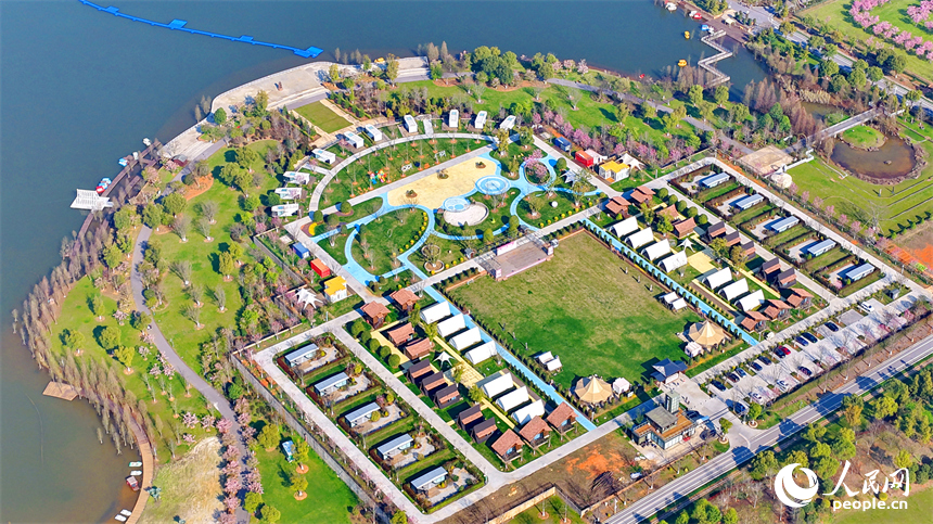 各式各樣的民宿木屋、露營帳篷相映成趣，吸引游客前來體驗游玩，樂享春光。人民網記者 朱海鵬攝