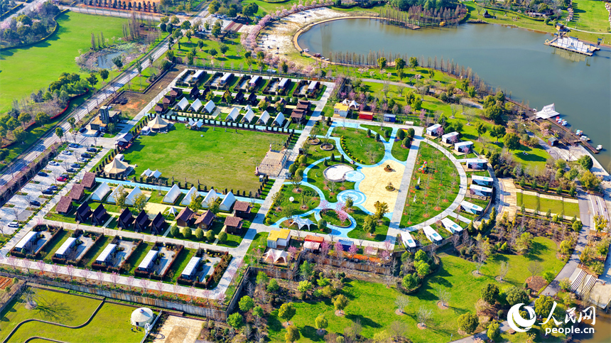 各式各樣的民宿木屋、露營帳篷相映成趣，吸引游客前來體驗游玩，樂享春光。人民網記者 朱海鵬攝