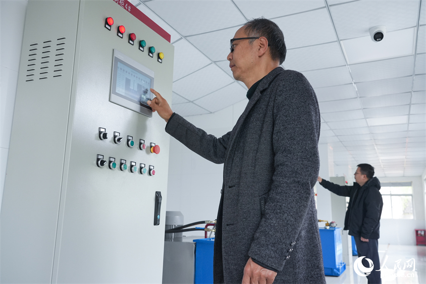 工作人员在控制室内按下开闸按钮。人民网 孔文进摄