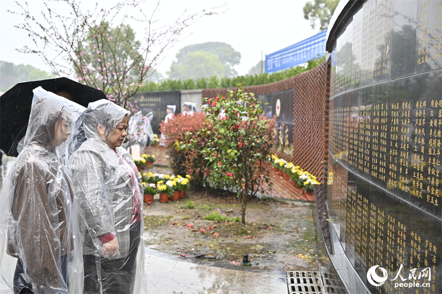 家属久久凝视着纪念墙上捐献者姓名。人民网记者 时雨摄