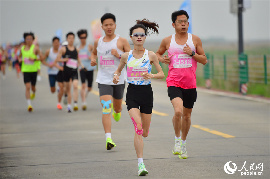 跑友们奔跑在被誉为“中国最美水上公路”的永吴公路赛道上。人民网记者 时雨摄