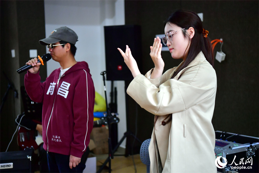 扶光乐队排练室内，盲人乐队演奏歌曲，手语老师进行“翻译”。人民网记者 时雨摄