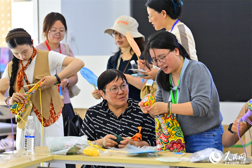 崇义县过埠镇泮江村的一处乡村旅游景点，外国游客在体验制作客家香囊和艾草锤。人民网记者 朱海鹏摄