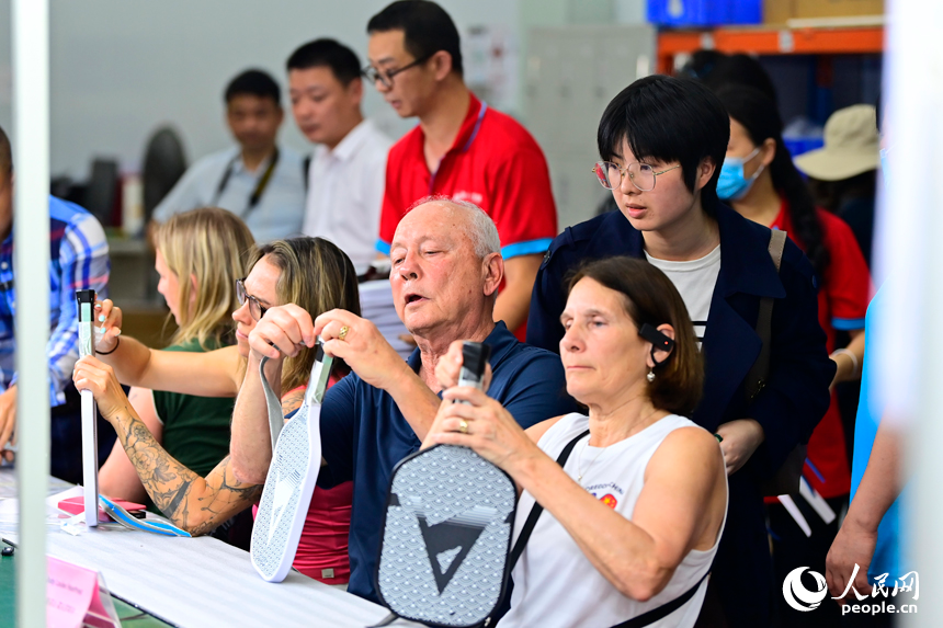 来自美国的匹克球运动爱好者体验匹克球拍制作。人民网记者 朱海鹏摄