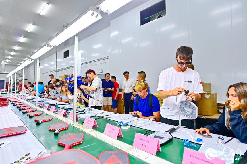 来自美国的匹克球运动爱好者体验匹克球拍制作。人民网记者 朱海鹏摄
