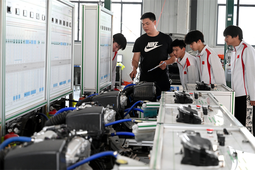 学生在老师的带领下进行汽车组装及维修实训。
