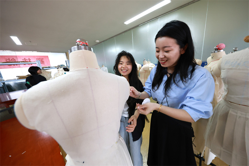 学生在老师的带领下进行汽车组装及维修实训。