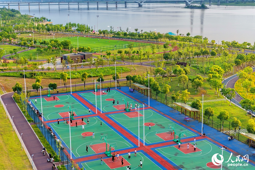 南昌縣象湖濱江江灘體育公園內，市民在健身鍛煉、踢足球、打籃球。人民網記者 朱海鵬攝