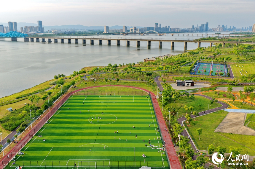 南昌縣象湖濱江江灘體育公園內，市民在健身鍛煉、踢足球、打籃球。人民網記者 朱海鵬攝