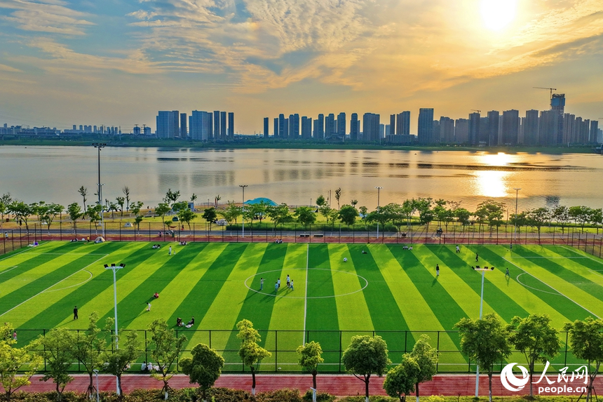 南昌縣象湖濱江江灘體育公園內，市民在健身鍛煉、踢足球、打籃球。人民網記者 朱海鵬攝