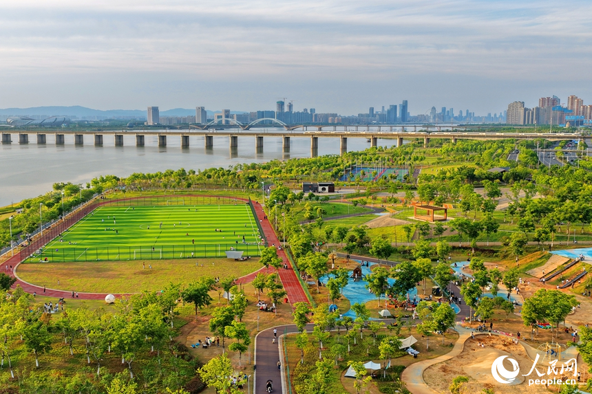 南昌縣象湖濱江江灘體育公園內，市民在健身鍛煉、踢足球、打籃球。人民網記者 朱海鵬攝