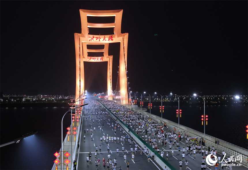 2026南昌萬人夜跑活動30日晚鳴笛開跑。圖為跑友奔跑在洪州大橋上。人民網記者 時雨攝