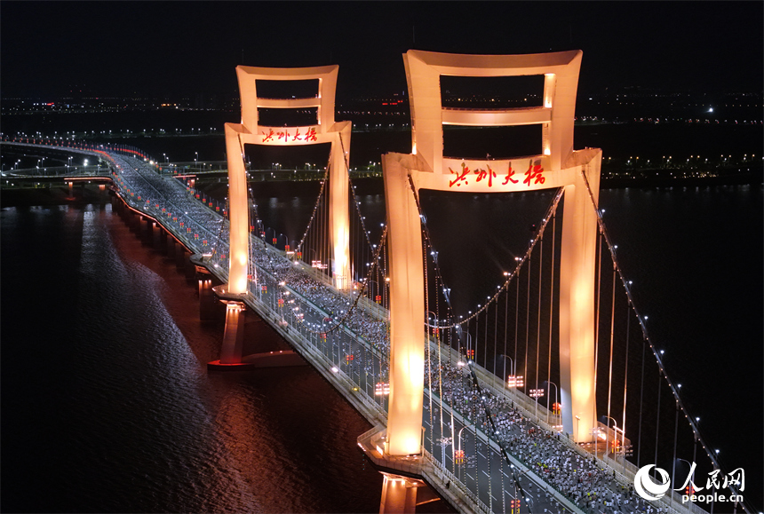 2026南昌萬人夜跑活動30日晚鳴笛開跑。圖為跑友奔跑在洪州大橋上。人民網記者 時雨攝