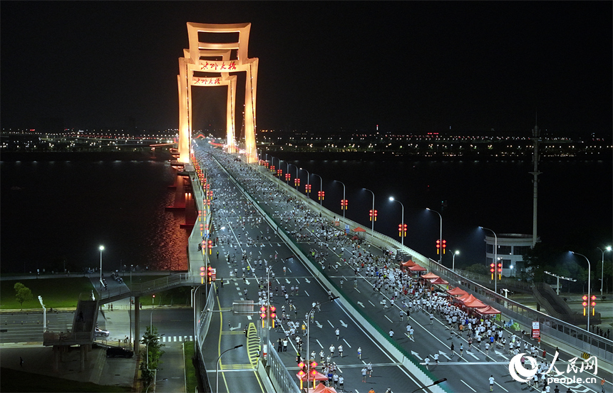 2026南昌萬人夜跑活動30日晚鳴笛開跑。圖為跑友奔跑在洪州大橋上。人民網記者 時雨攝
