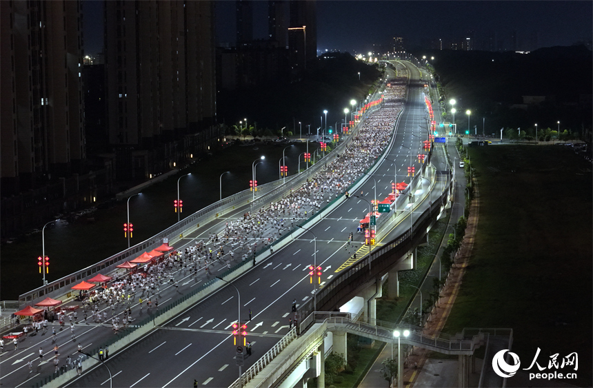 2026南昌萬人夜跑活動30日晚鳴笛開跑。圖為跑友奔跑在洪州大橋上。人民網記者 時雨攝