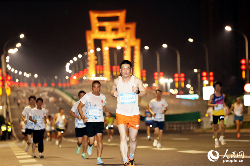 2026南昌萬人夜跑活動30日晚鳴笛開跑。圖為跑友奔跑在洪州大橋上。人民網記者 時雨攝