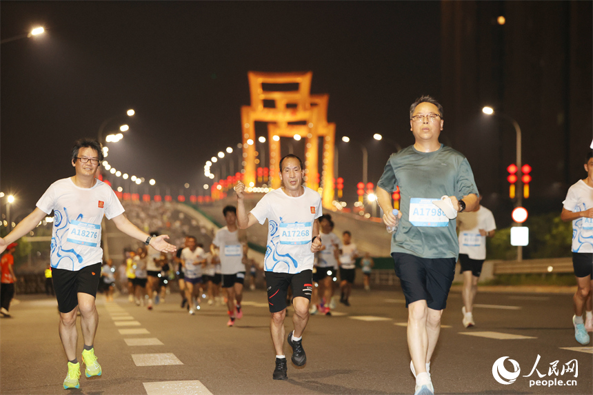 2026南昌萬人夜跑活動30日晚鳴笛開跑。圖為跑友奔跑在洪州大橋上。人民網記者 時雨攝