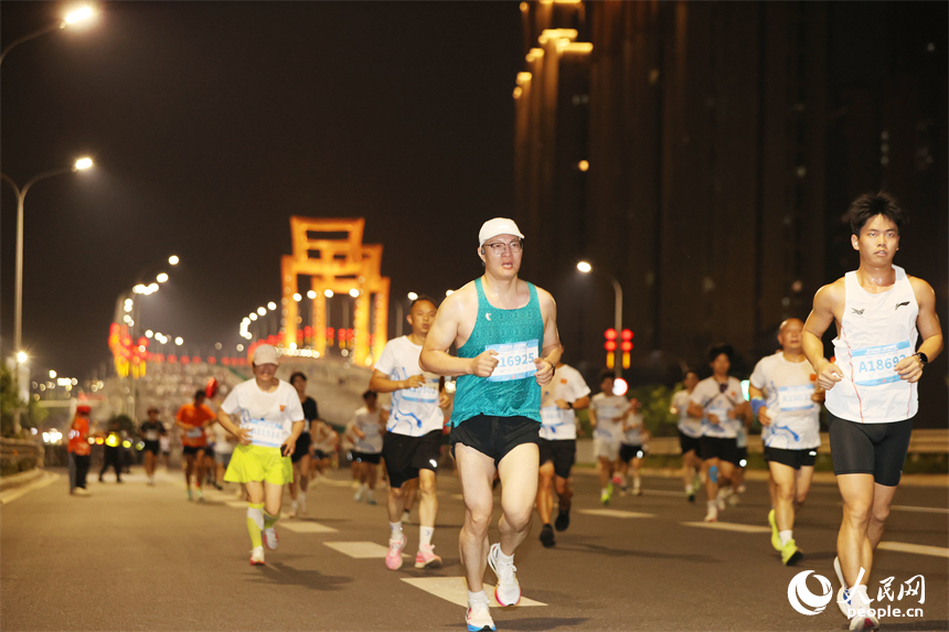 2026南昌萬人夜跑活動30日晚鳴笛開跑。圖為跑友奔跑在洪州大橋上。人民網記者 時雨攝