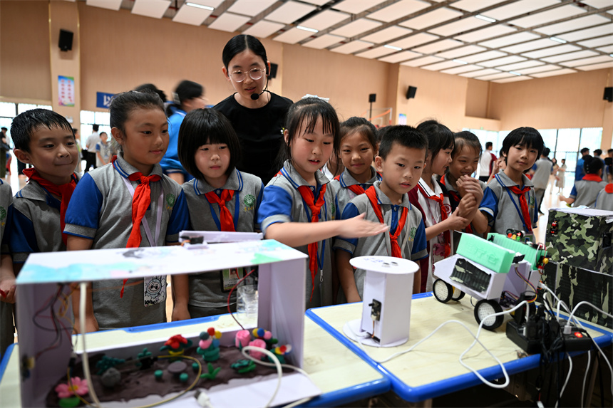 江西省抚州东乡区第七中学学生展示、观看学生创客创作的电子控制、智能设备等作品。何江华摄
