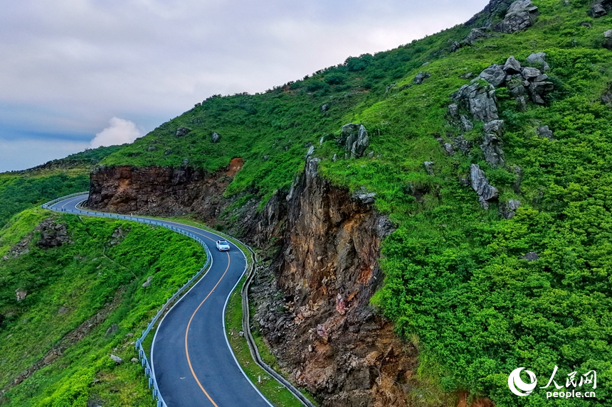 车辆行驶在上犹县双溪乡草山的盘山公路上，蜿蜒的“四好农村路”穿行翠绿山间，将村庄和产业基地串联互通。人民网记者 朱海鹏摄