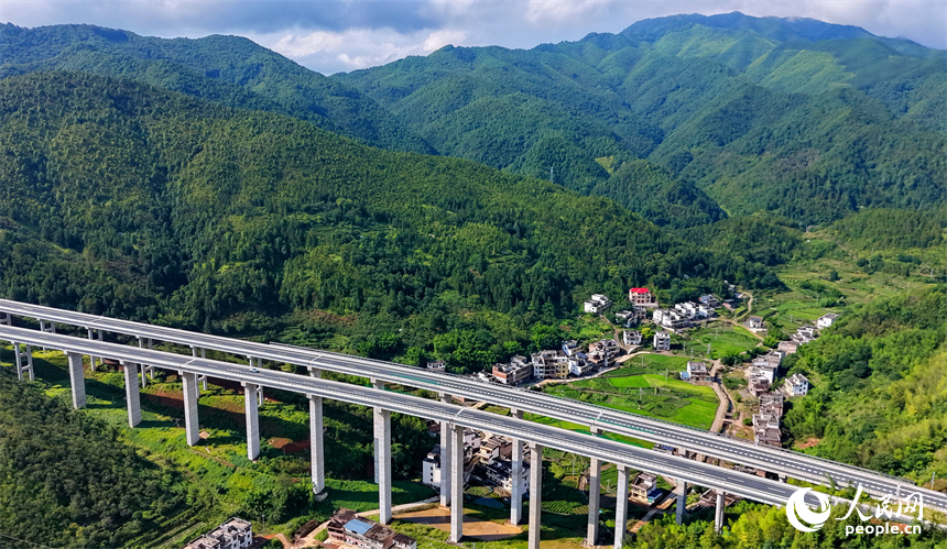 遂大高速公路江西省赣州市上犹县梅水乡园村大桥段，车辆往来驰骋，与村庄民居、群山绿树相映成景。人民网记者 朱海鹏摄