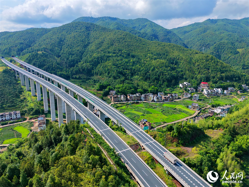 遂大高速公路江西省赣州市上犹县梅水乡园村大桥段，车辆往来驰骋，与村庄民居、群山绿树相映成景。人民网记者 朱海鹏摄