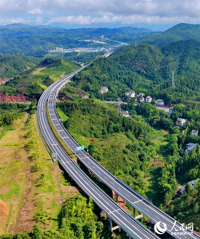 遂大高速公路江西省赣州市上犹县梅水乡园村大桥段，车辆往来驰骋，与村庄民居、群山绿树相映成景。人民网记者 朱海鹏摄