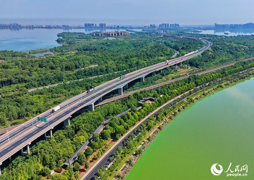 九江市八里湖新区，高速公路、城际高铁、城市道路和环湖公路等交通通道如银龙穿翠纵横交错，与河湖、草木、房屋相映成趣，构成一幅路畅景美的夏日山水城乡画卷。人民网记者 朱海鹏摄