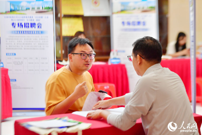 江西中医药大学专场招聘会上，毕业生正在和招聘人员交谈。人民网记者 时雨摄