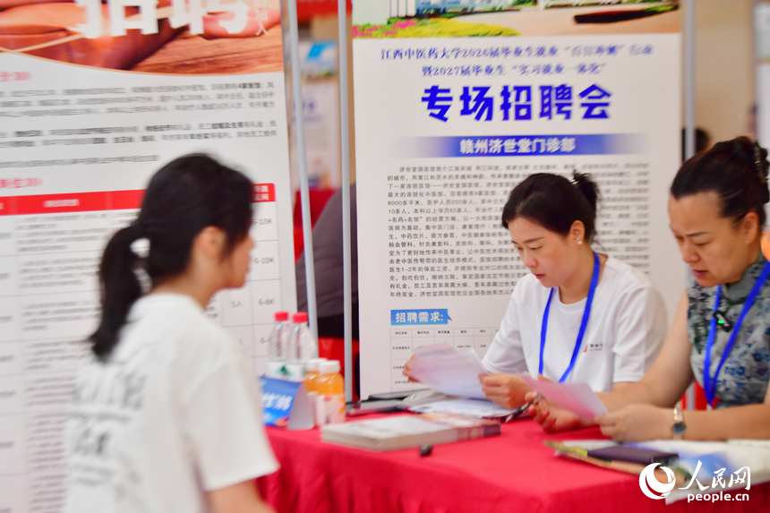 江西中医药大学专场招聘会上，招聘人员查看毕业生投递的简历。人民网记者 时雨摄