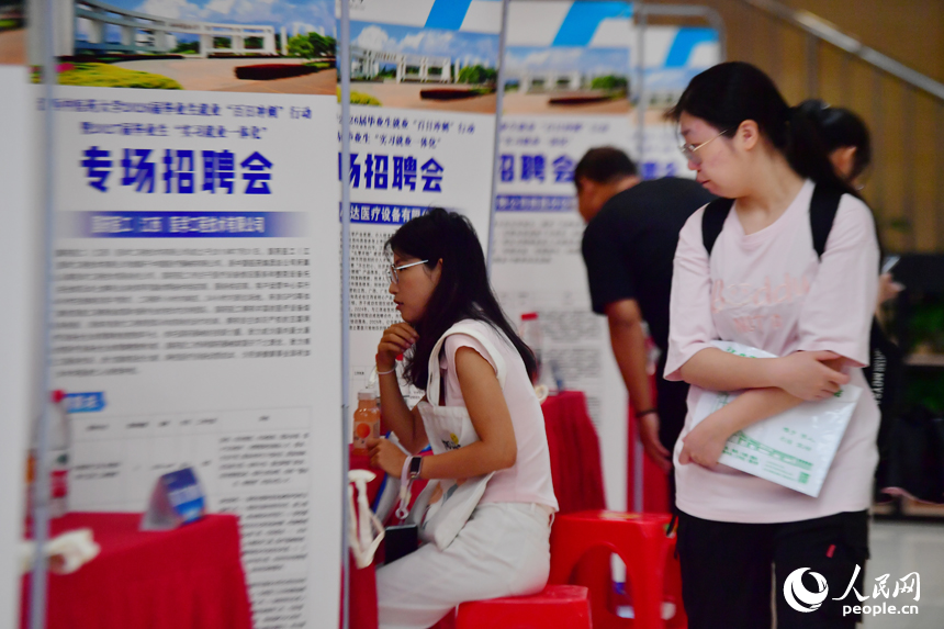 江西中医药大学专场招聘会上，毕业生正在查看招聘启事。人民网记者 时雨摄