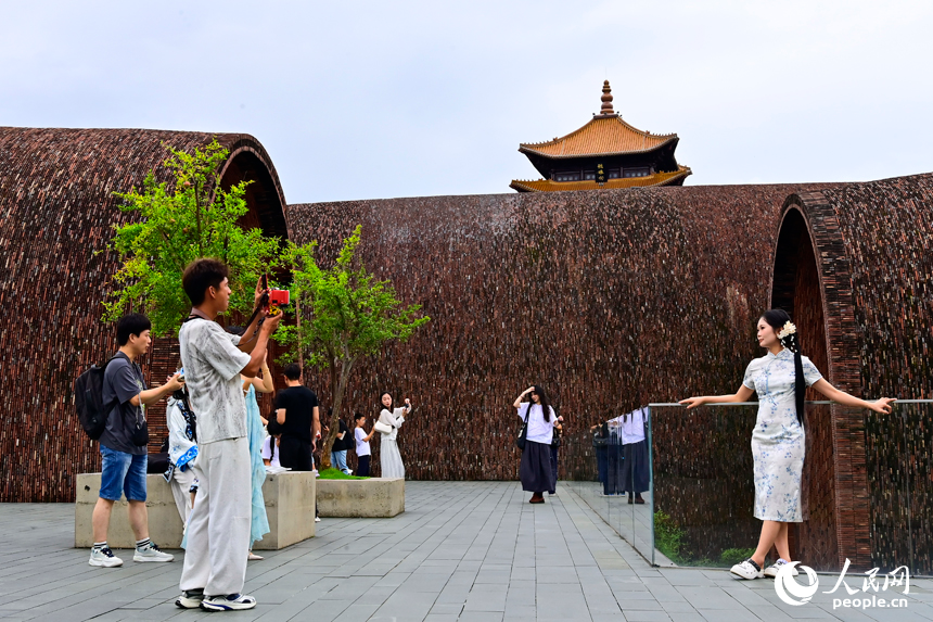 景德镇市陶阳里历史文化旅游区，旅拍摄影师在打卡点给游客拍照留影。人民网记者 朱海鹏摄
