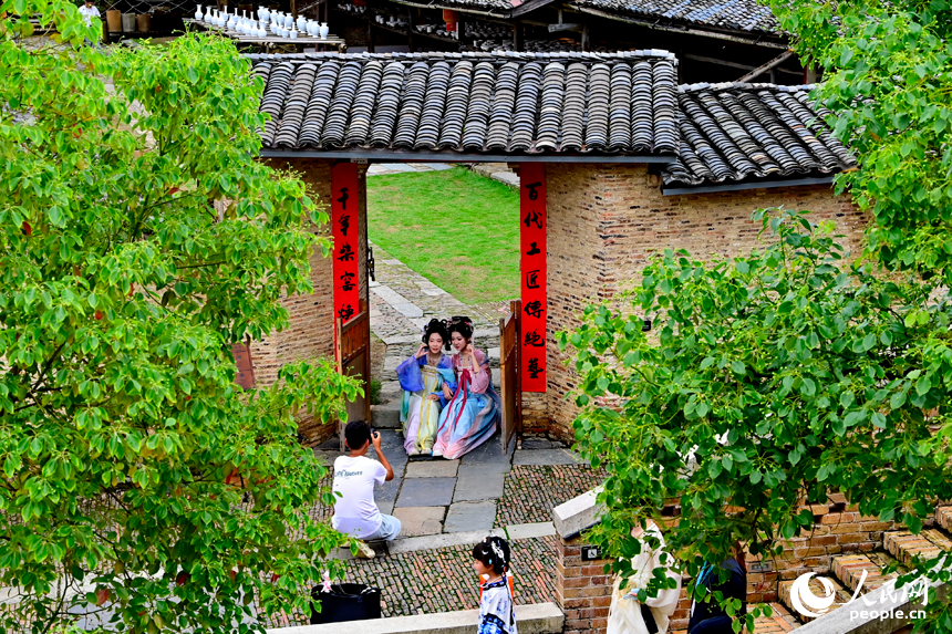 景德镇市陶阳里历史文化旅游区，旅拍摄影师在打卡点给游客拍照留影。人民网记者 朱海鹏摄
