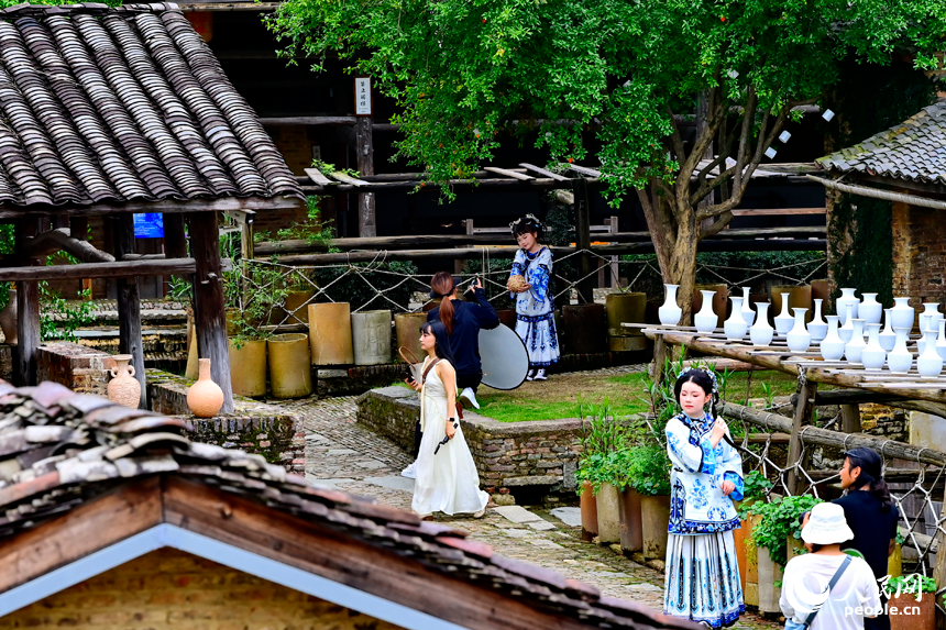 景德镇市陶阳里历史文化旅游区，旅拍摄影师在打卡点给游客拍照留影。人民网记者 朱海鹏摄