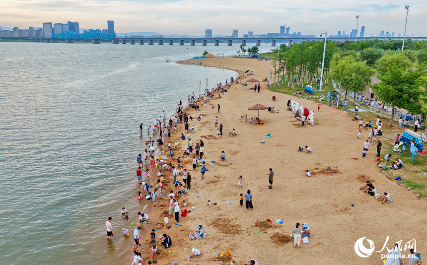 南昌縣東新鄉的七星灣泳場，眾多市民和游客在江邊沙灘嬉戲游玩。人民網記者 朱海鵬攝