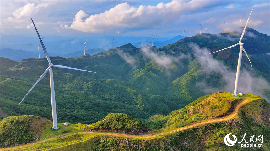 上猶縣雙溪鄉筑峰頂，山巒疊翠、雲蒸霞蔚，風力發電機扇葉迎風旋轉，繪就山野獨特景致，吸引游客前來觀光游玩。人民網記者 朱海鵬攝