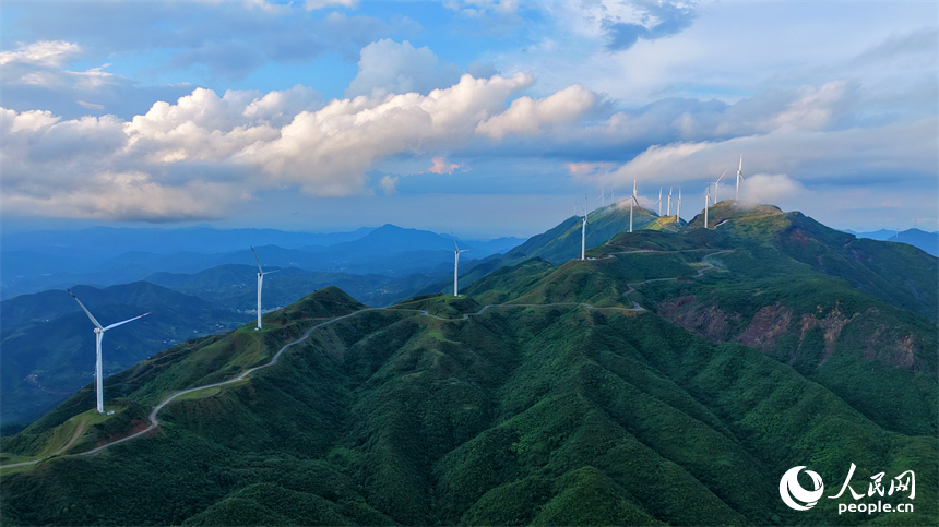 上犹县双溪乡筑峰顶，山峦叠翠、云蒸霞蔚，风力发电机扇叶迎风旋转，绘就山野独特景致，吸引游客前来观光游玩。人民网记者 朱海鹏摄