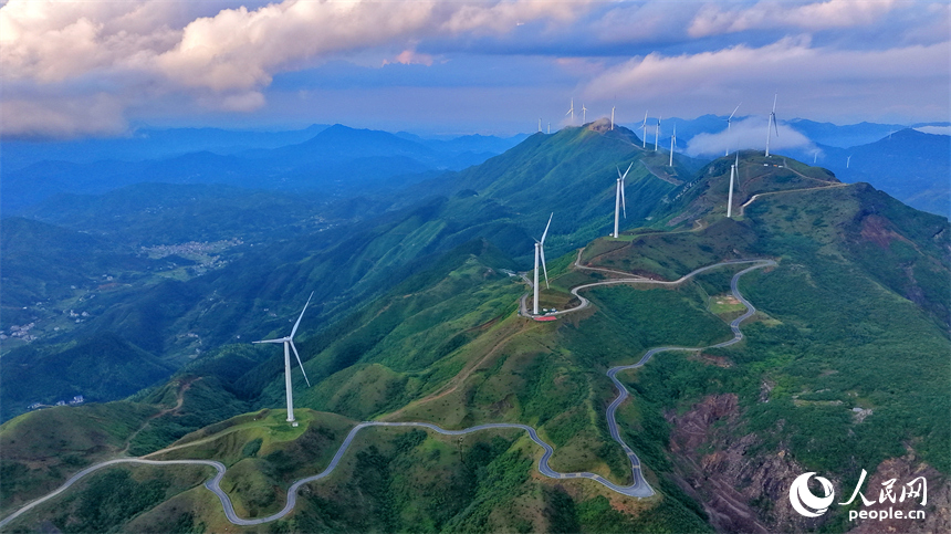 上犹县双溪乡筑峰顶，山峦叠翠、云蒸霞蔚，风力发电机扇叶迎风旋转，绘就山野独特景致，吸引游客前来观光游玩。人民网记者 朱海鹏摄